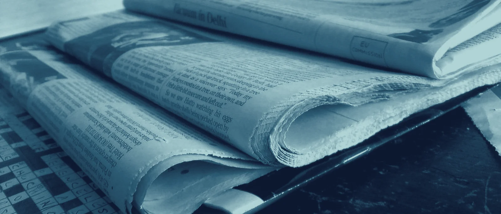 Folded newspapers, stacked on a table